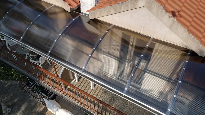 Nadstrešnica s polikarbonatnim pločama postavljena cijelom dužinom balkona, pogled iz ptičje perspektive